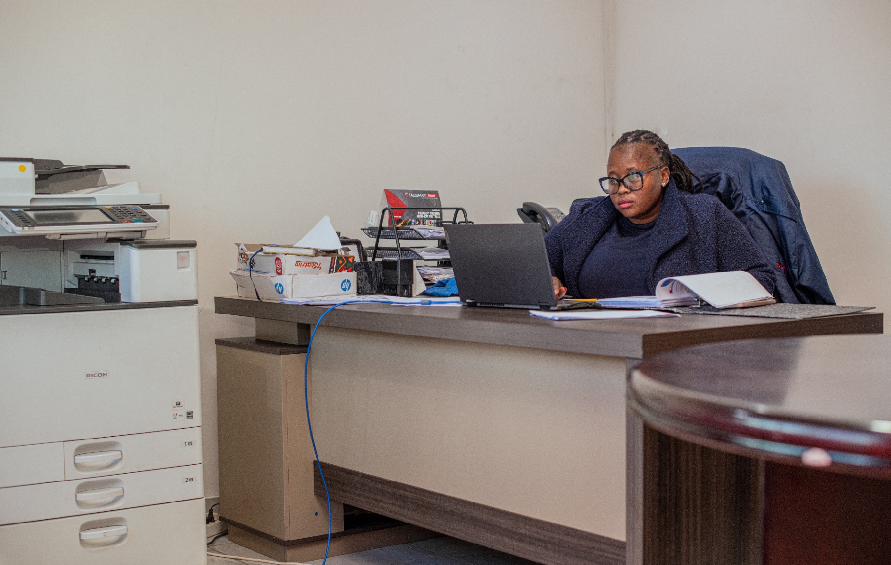 A Minatlou Security administrator working at her desk in the operations office